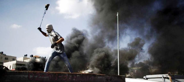 Un joven palestino lanza, desde una azotea, piedras contra policías israelíes | Foto: rtve.es