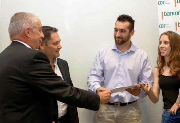 Hugo Escañuela, vicepresidente de Bancor entregando la escritura a los nuevos propietarios | Foto: prensa Bancor.